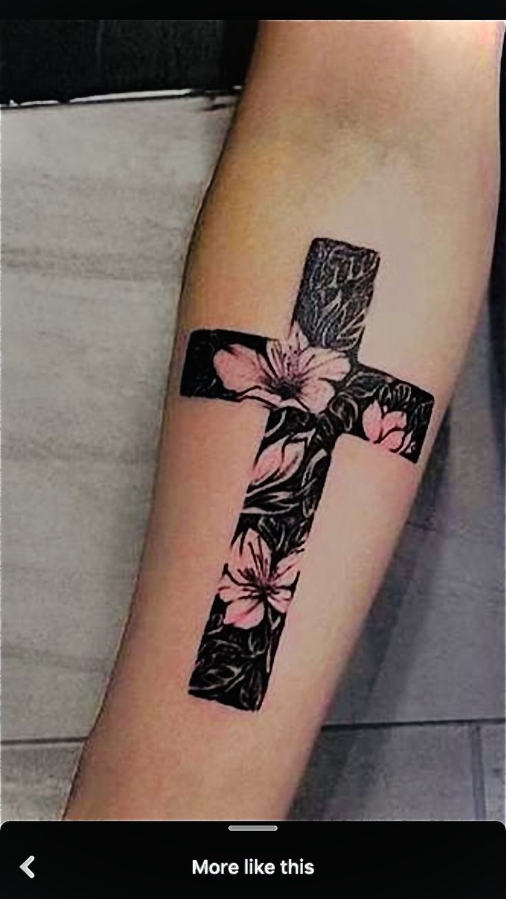 a cross tattoo with flowers on it