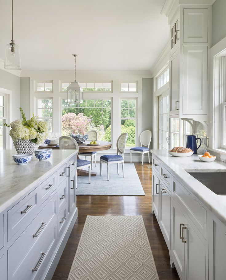 a large kitchen with white cabinets and counter tops