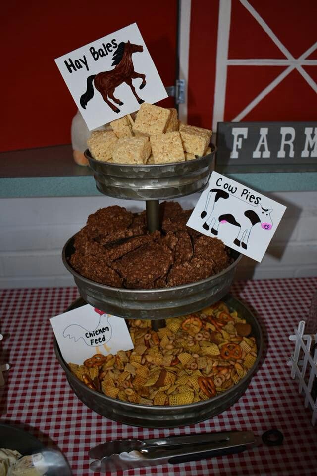 three tiered trays filled with crackers and other snacks on a checkered tablecloth