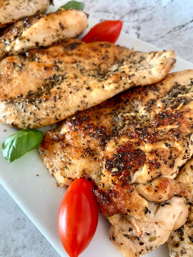 some chicken and tomatoes on a white plate