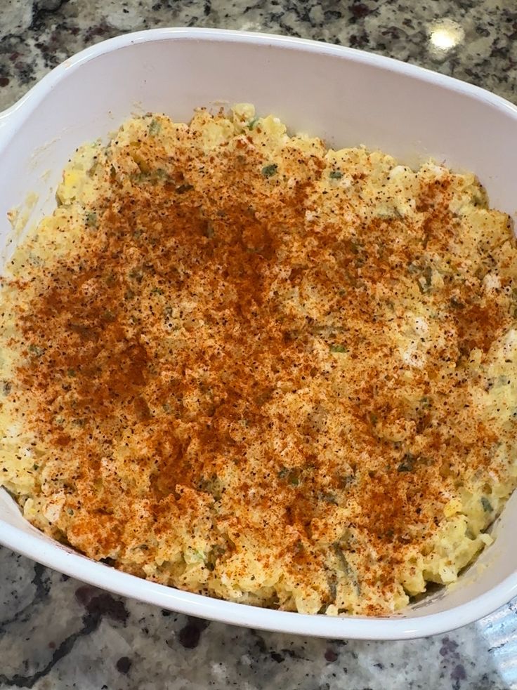 a casserole dish with cheese and seasoning in it