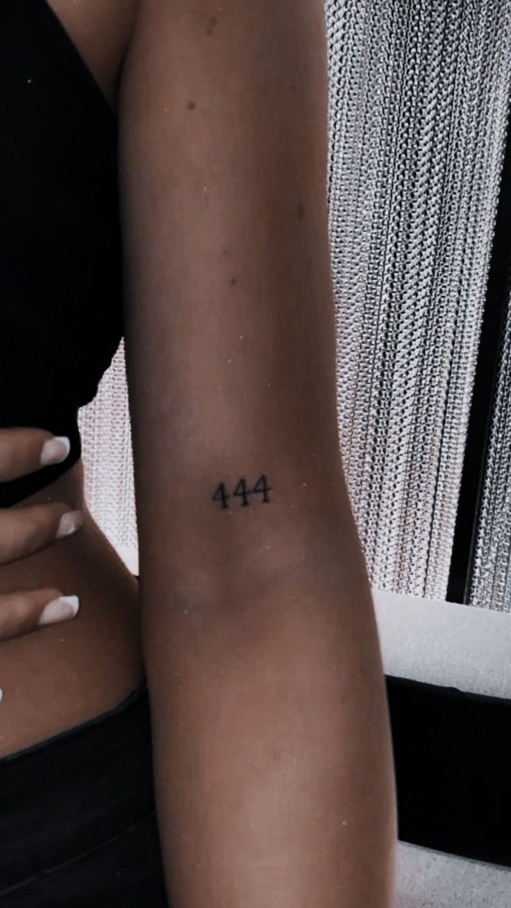 a woman with a small tattoo on her left arm and the number forty four behind her