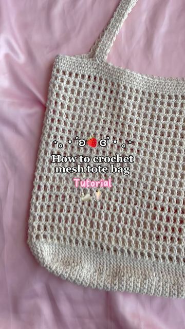 a white crocheted bag sitting on top of a bed