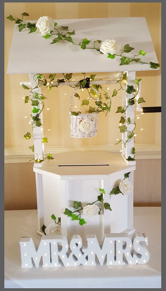 a wedding cake stand with flowers and greenery on the top for mr & mrs