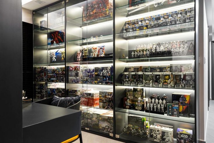 a room filled with lots of different types of action figures on display in glass cases