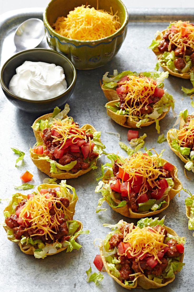 many small sandwiches with toppings on a tray