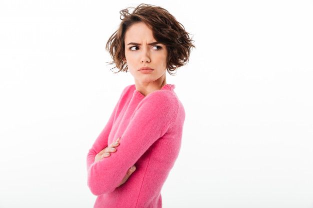 a woman in a pink sweater with her arms crossed