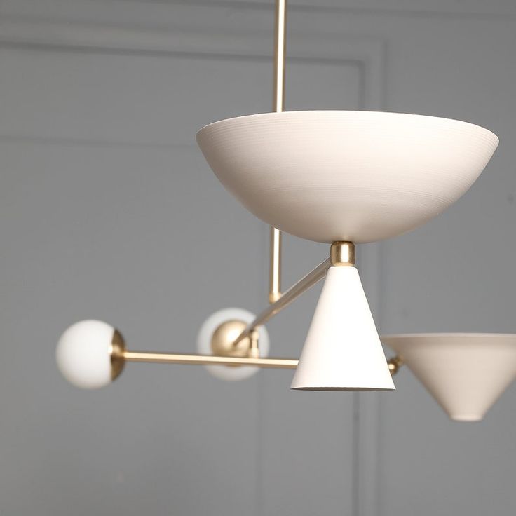 a white light fixture hanging from a ceiling in a room with gray walls and flooring