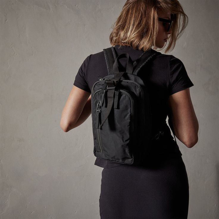 a woman wearing a black backpack and sunglasses