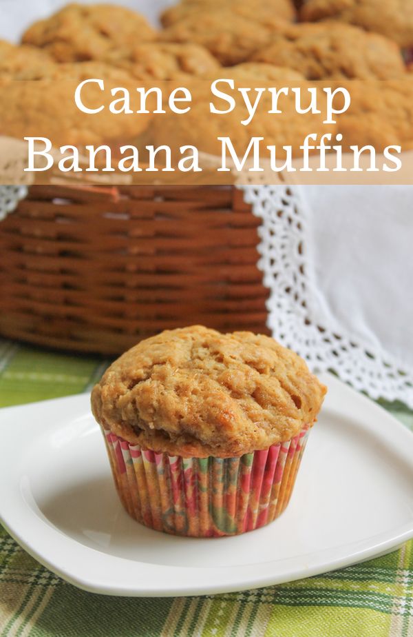 a muffin sitting on top of a white plate next to a wicker basket