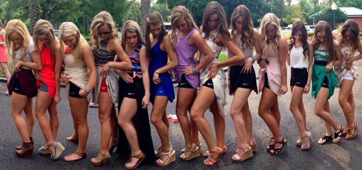 a group of young women standing next to each other in front of a parking lot