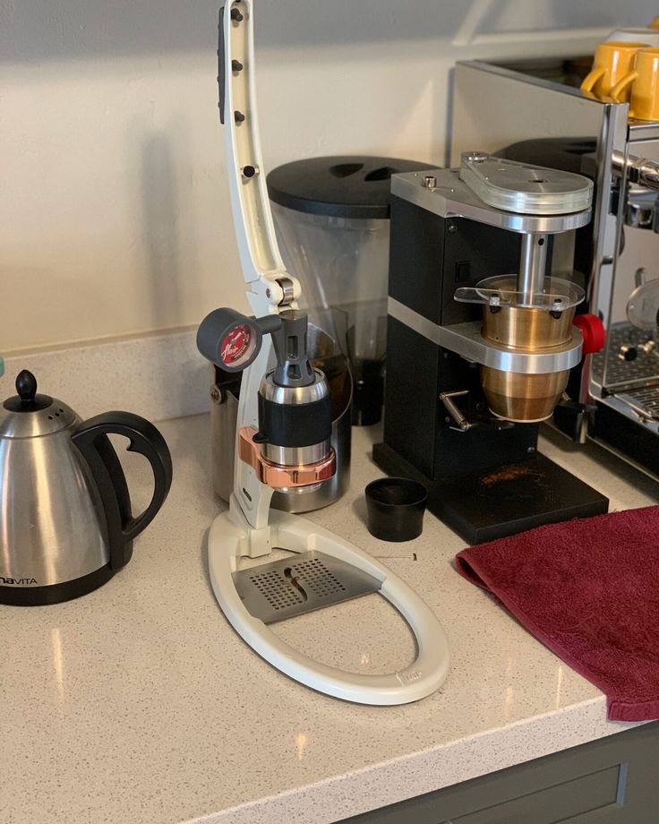 the coffee maker is sitting on the counter next to the tea pot and other items