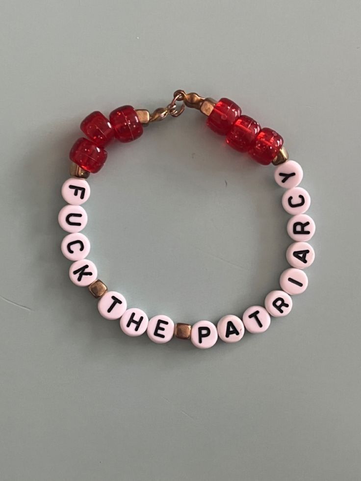 a red beaded bracelet with white letters and beads that say rock the party on it