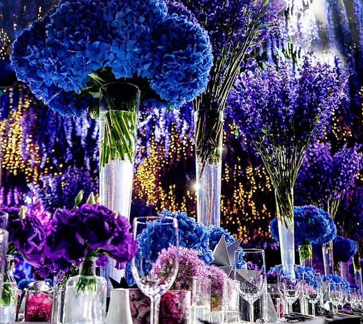 the table is set with purple and blue flowers