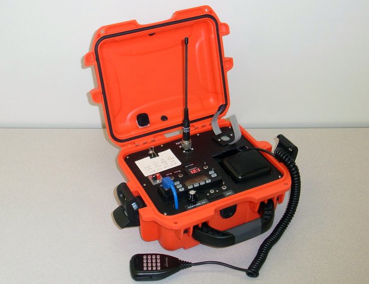 an orange and black case with wires connected to it on top of a white table