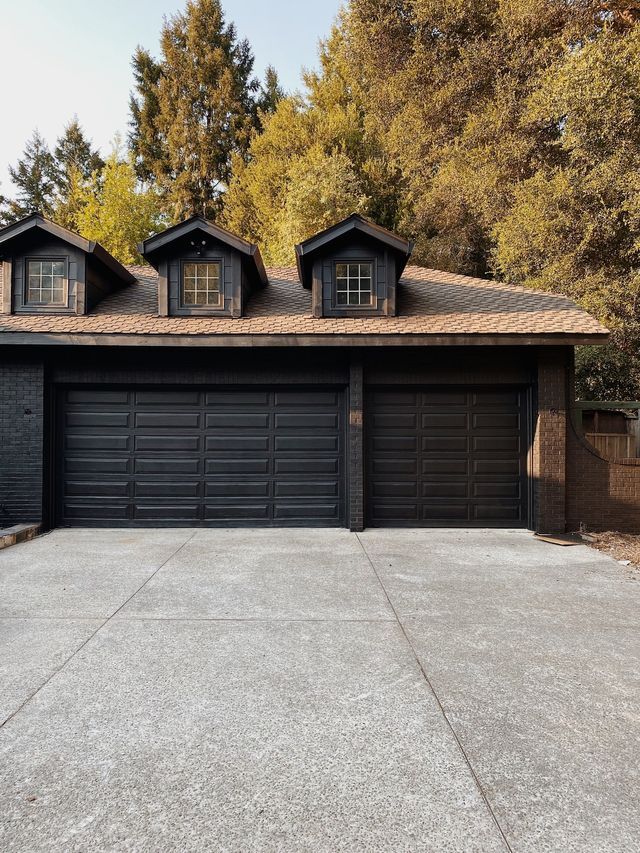 a black garage with three windows and two doors