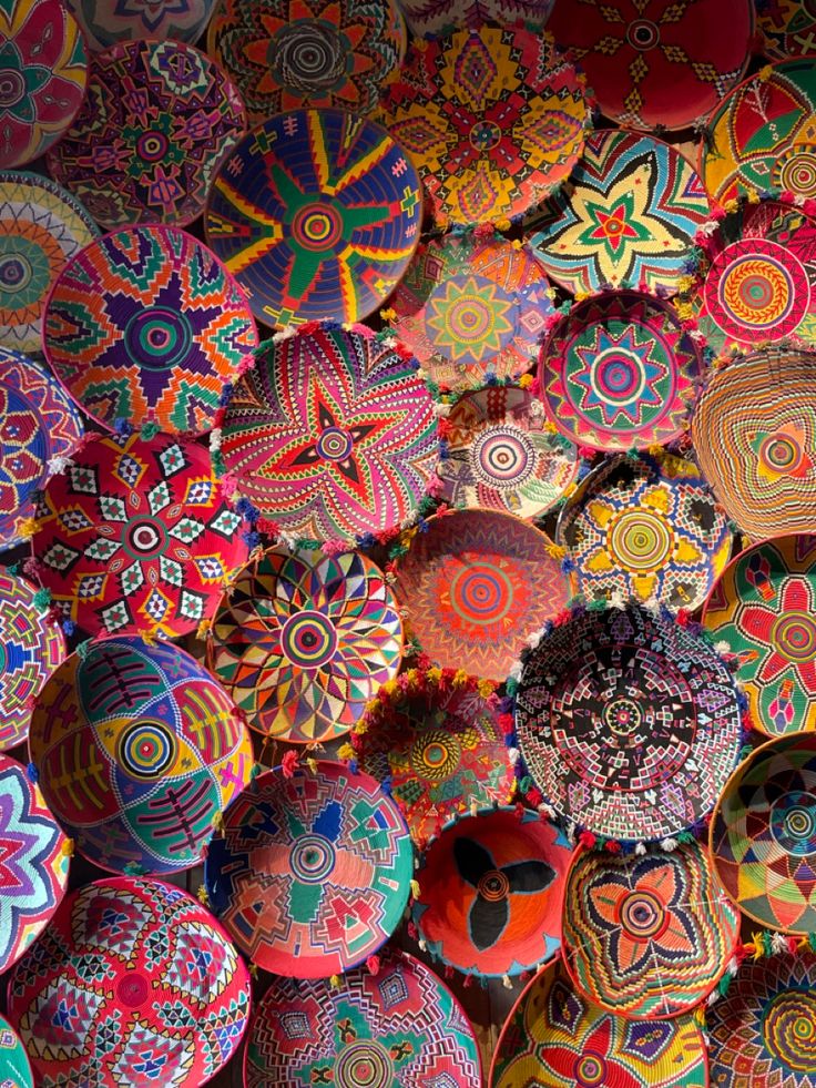 many colorful balls are stacked on top of each other in the shape of an intricate pattern