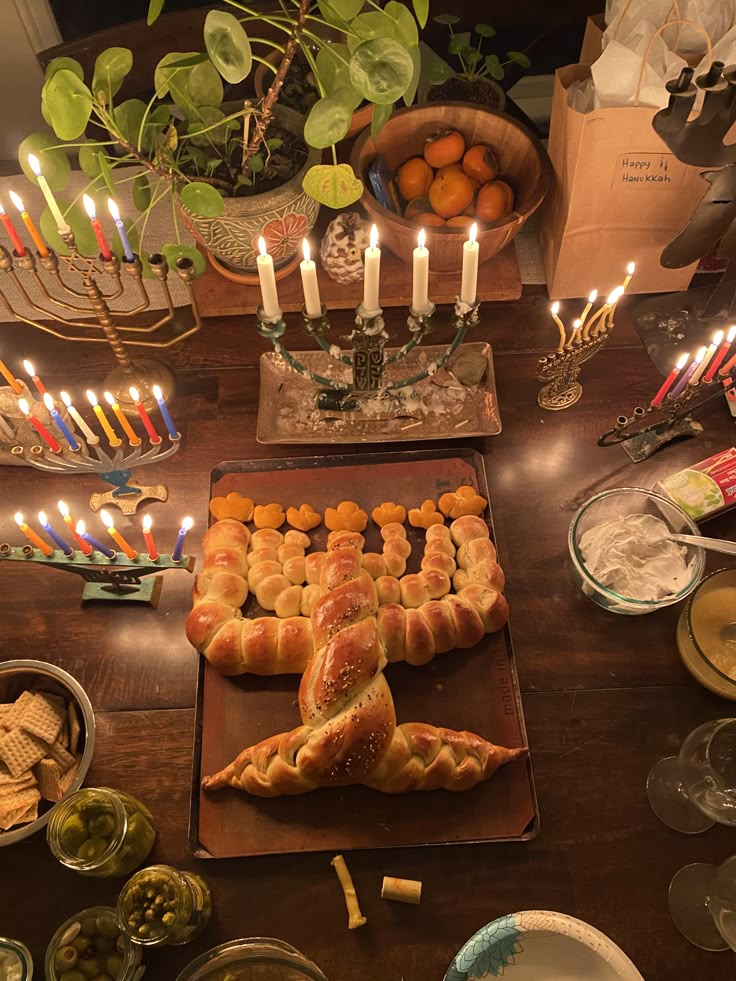 a wooden table topped with lots of food and candles