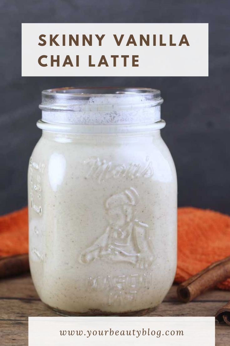 a mason jar filled with vanilla chai latte on top of a wooden table