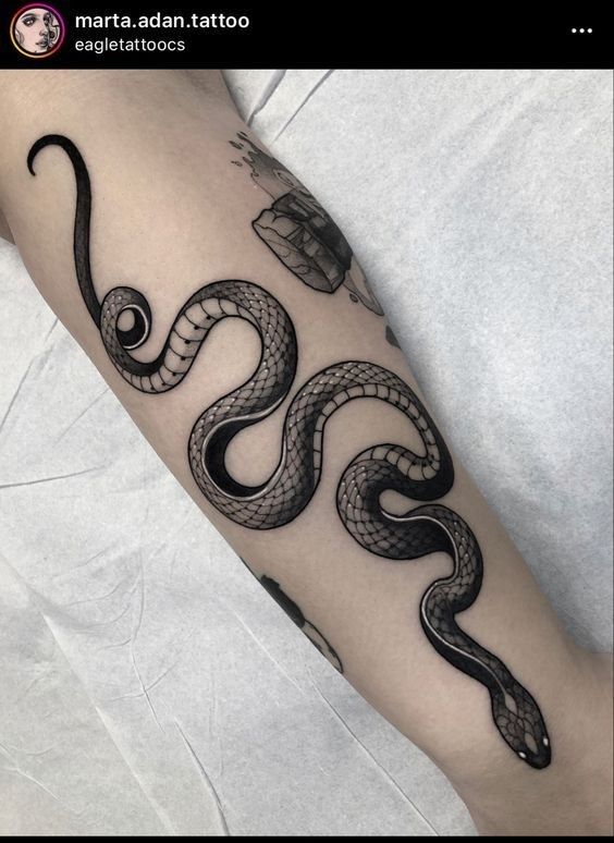 a black and white snake tattoo on the arm