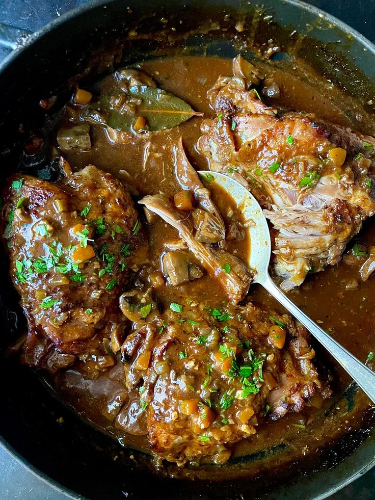 a pot filled with meat and vegetables covered in gravy