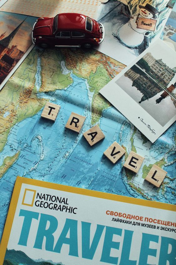 the word traveler spelled with scrabbles on top of a map and travel brochure