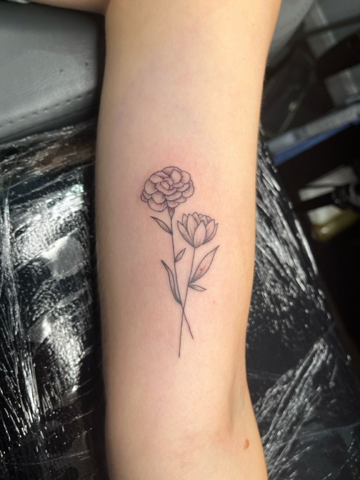 a small flower tattoo on the arm