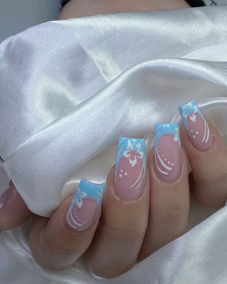 a woman's hand with pink and blue nail polish on it, holding a white cloth