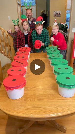 a group of people standing around a table with cupcakes on top of it