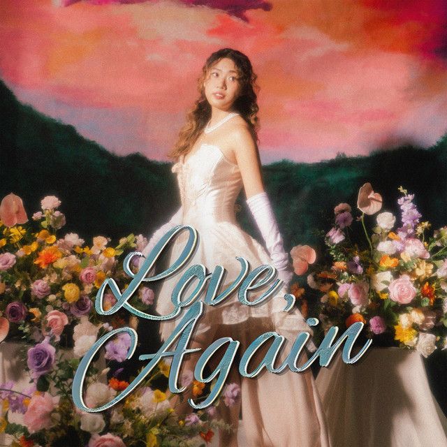 a woman standing in front of flowers with the words love again on it