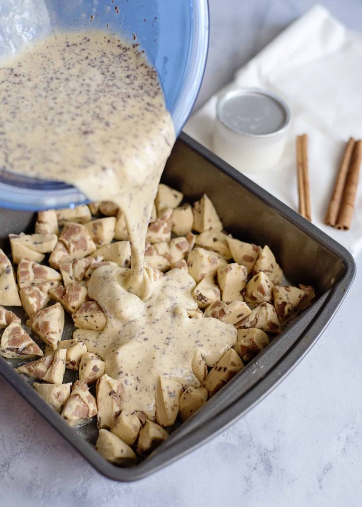 a pan filled with food sitting on top of a counter next to cinnamon sticks and spices