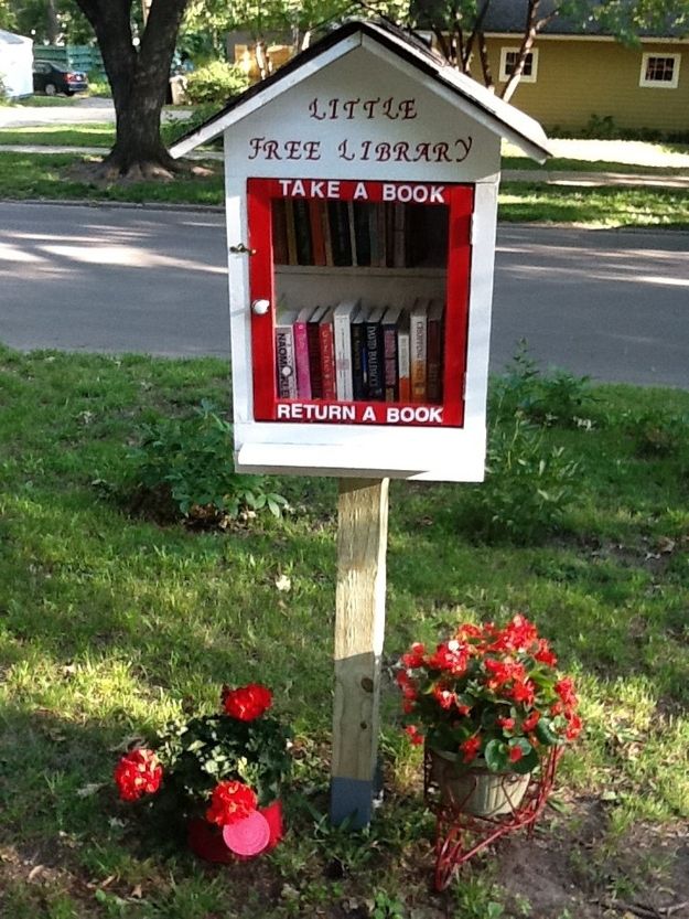 there is a sign that has been placed in the grass for people to read and take a book