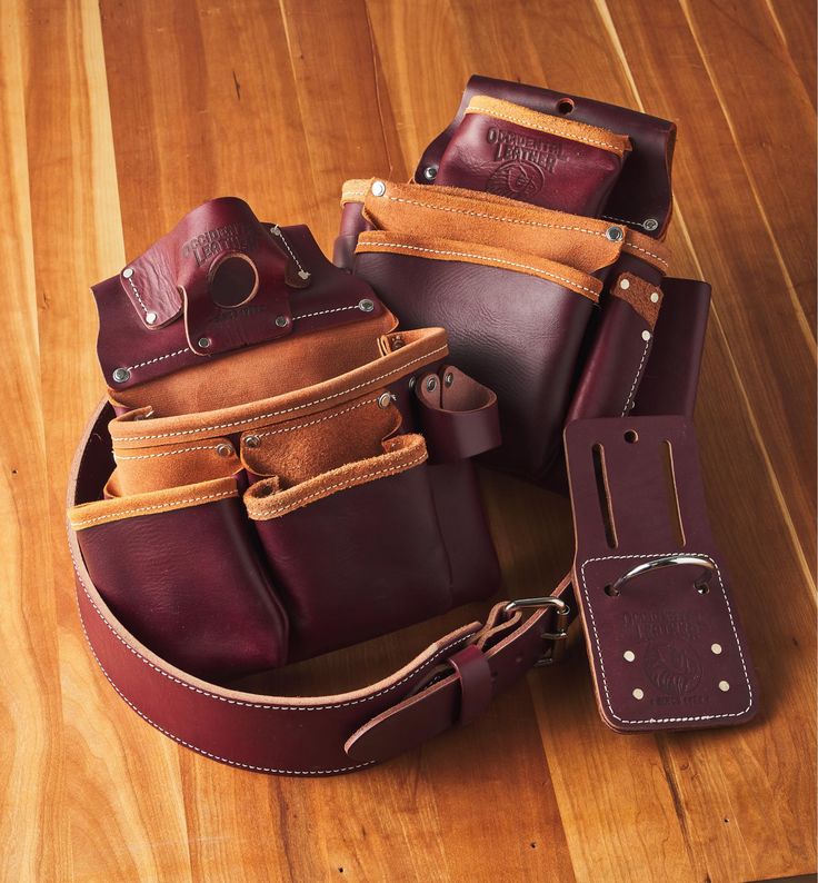 several different types of leather bags on a wooden floor