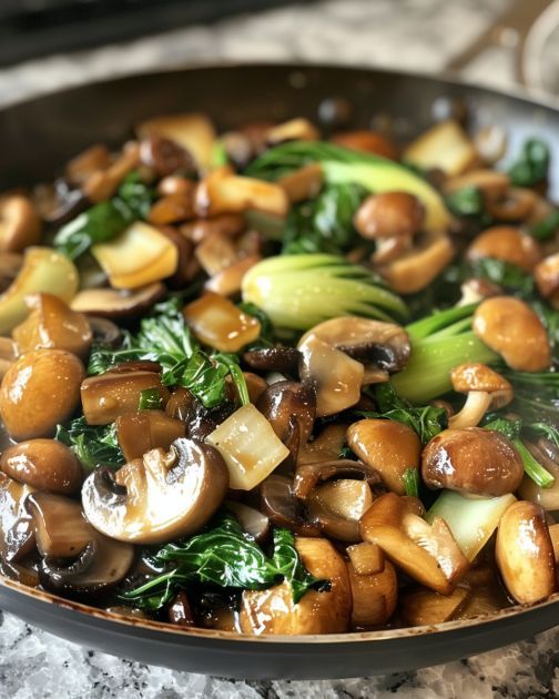 mushrooms, broccoli and other vegetables cooking in a skillet