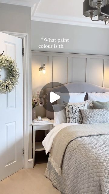 a bed room with a neatly made bed and a wreath hanging on the wall above it