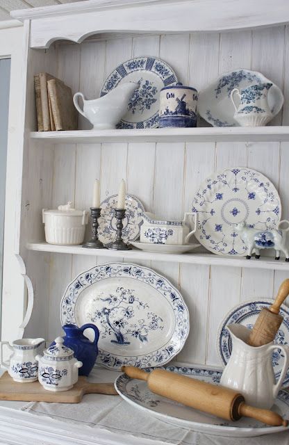 blue and white china is displayed on a shelf