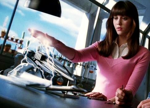 a woman standing in front of a desk with a computer on it