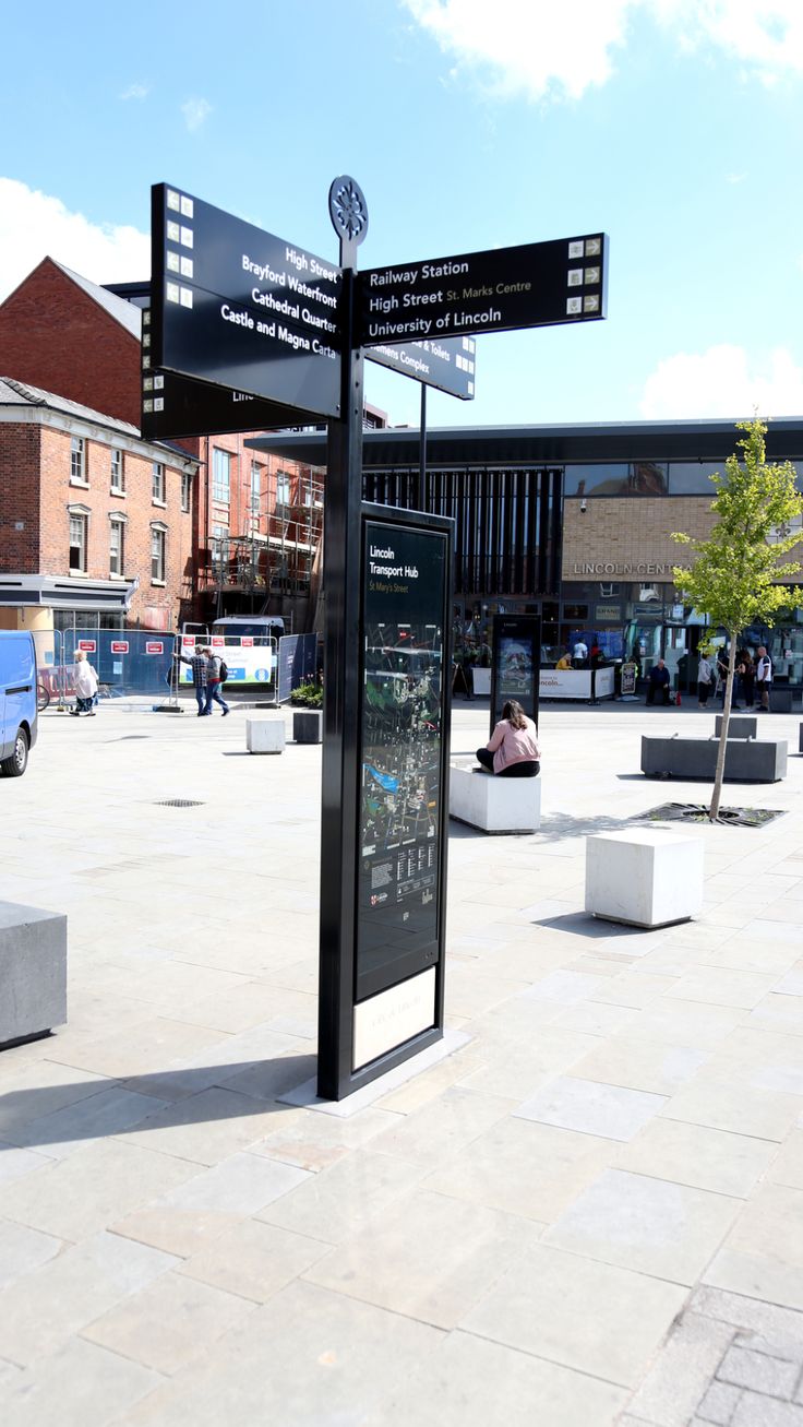 a sign in the middle of a public plaza