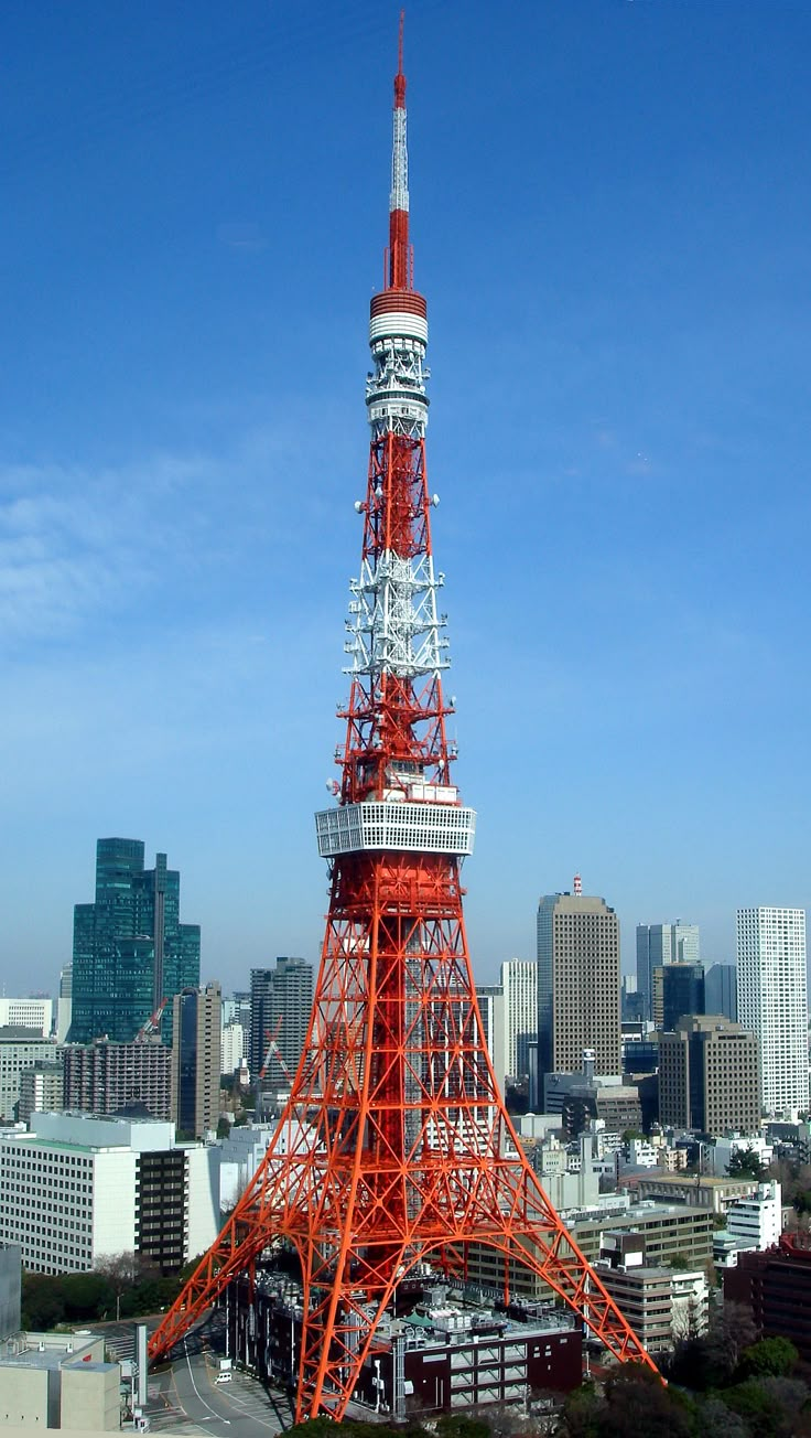 a red and white tower in the middle of a city