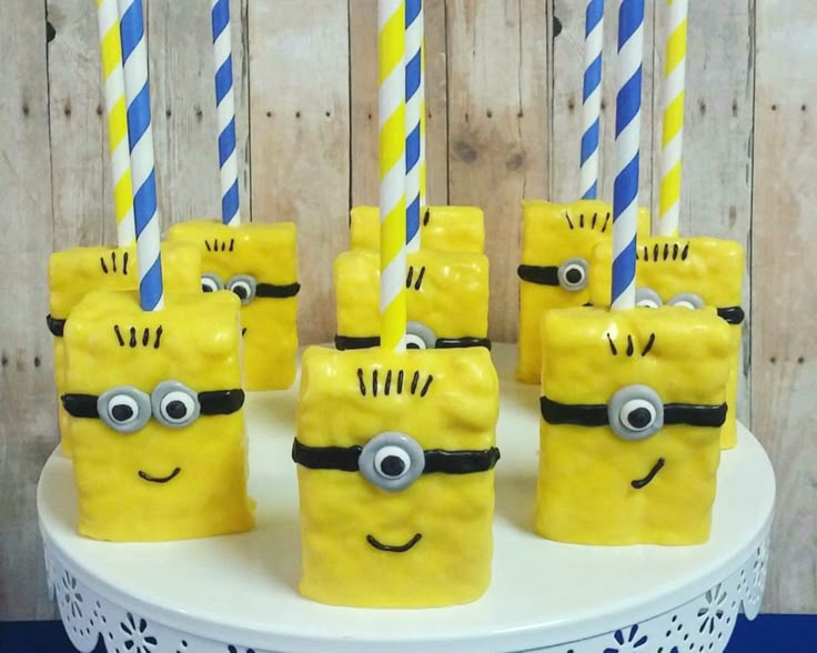 there are some yellow and blue candles with minion faces on them, one has eyes