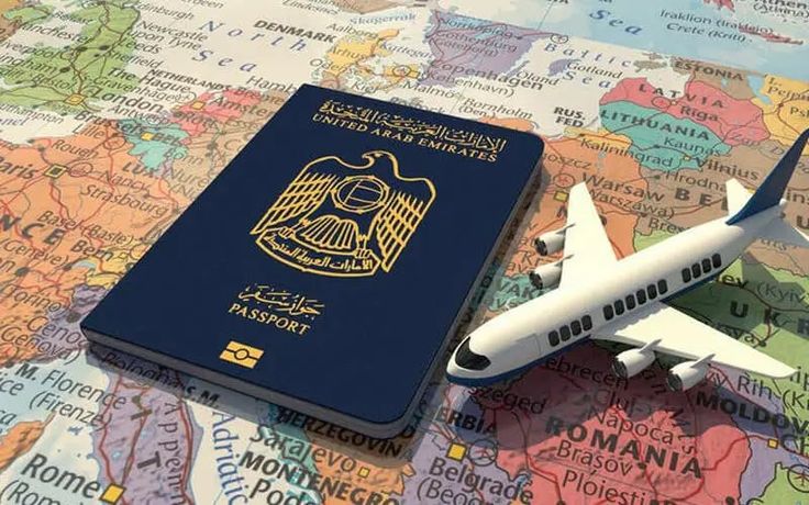 a model airplane sitting on top of a map next to a blue and yellow passport