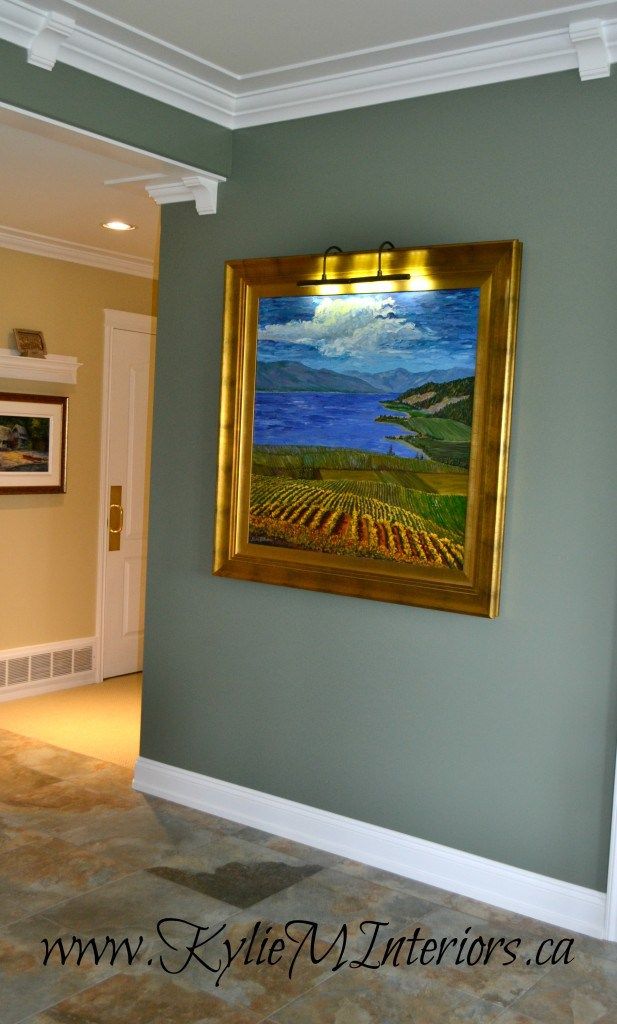 a painting hanging on the wall in a room with tile flooring and green walls