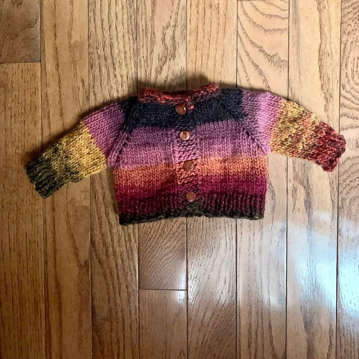 a colorful sweater sitting on top of a wooden floor