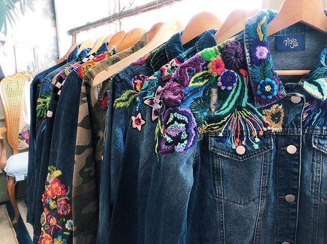 several denim jackets with colorful flowers on them