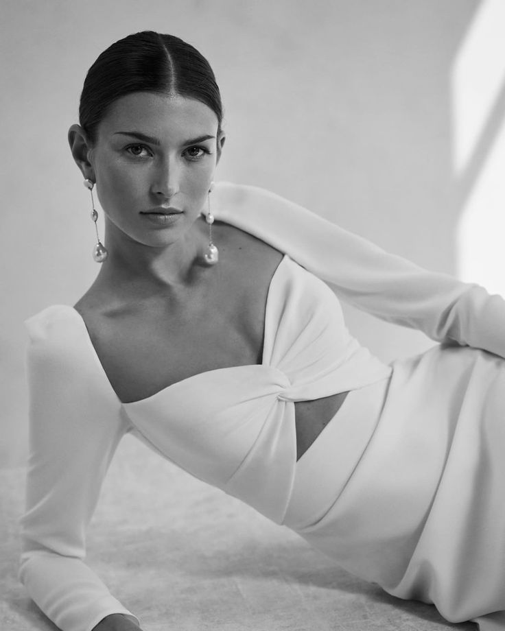 a woman laying on the ground wearing a white dress