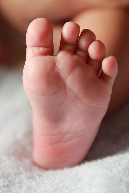 a close up of a baby's foot on a blanket