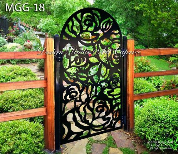 an iron gate in the middle of a garden