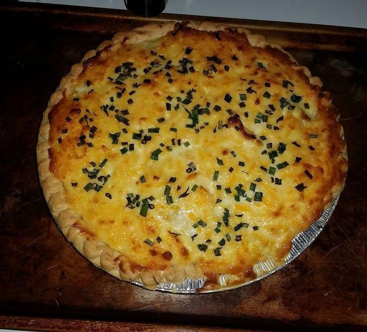 a cheesy pizza sitting on top of a wooden table