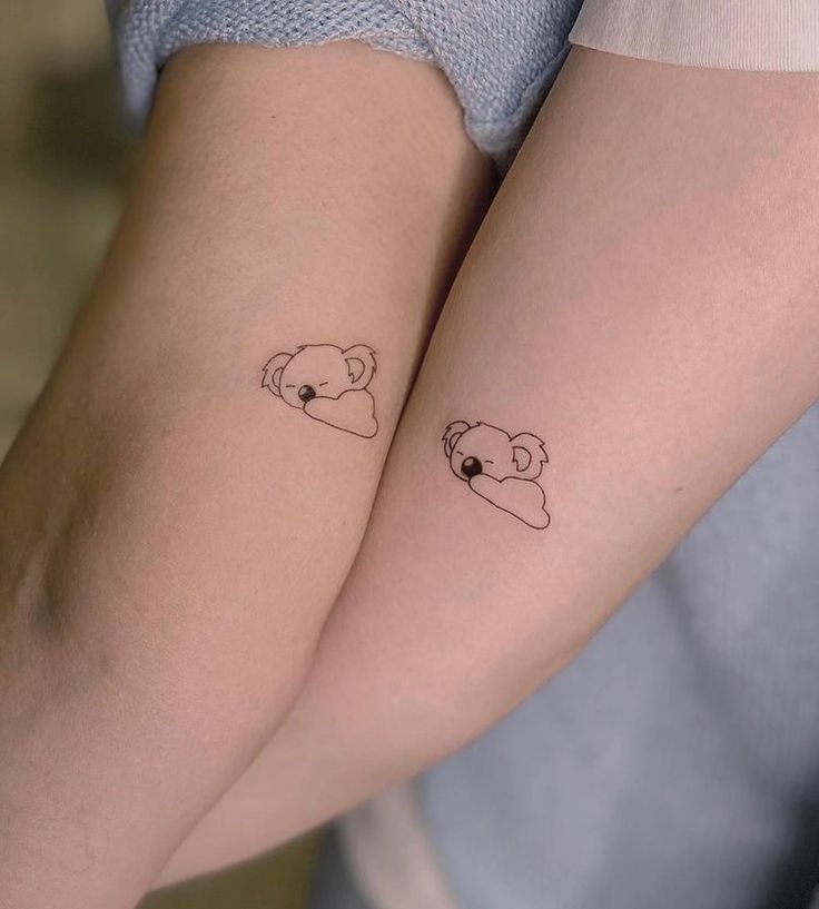 two people with matching tattoos on their arms, one has a bear and the other has a heart