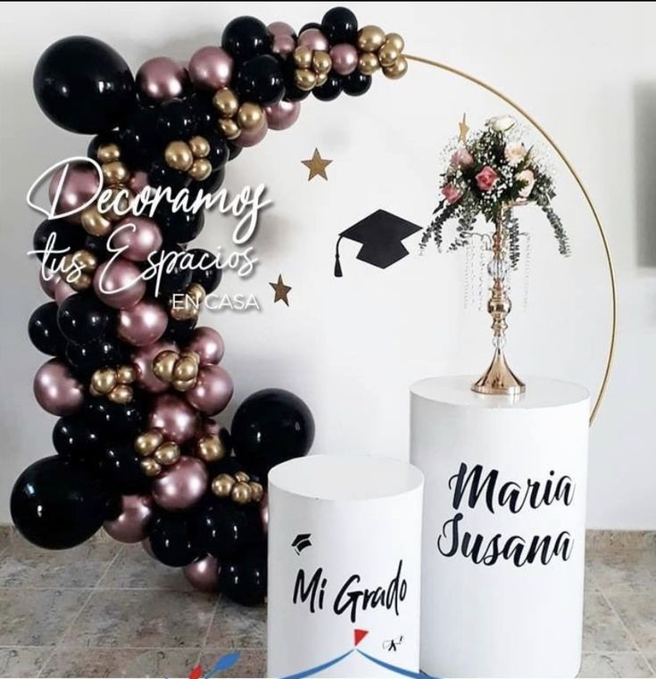 two vases with flowers and balloons in front of a graduation balloon arch that reads,